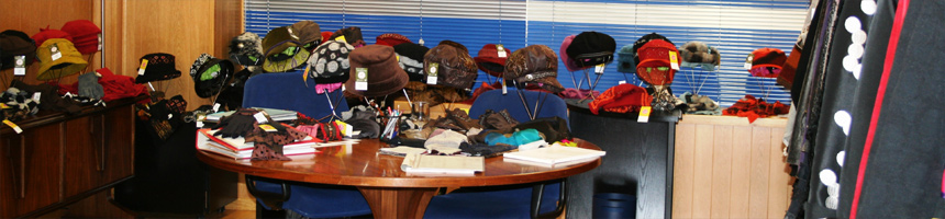Mesa con gorros y complementos expuestos en un showroom